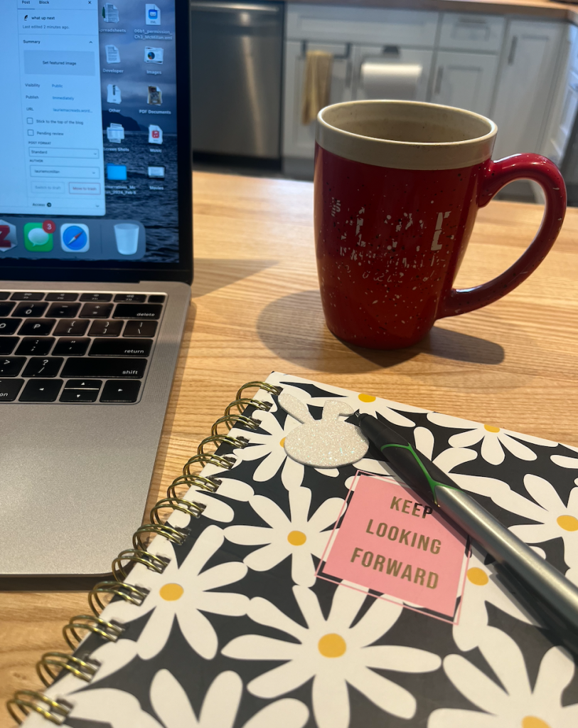 journal that says Keep Looking Forward with pen, laptop, and coffee mug